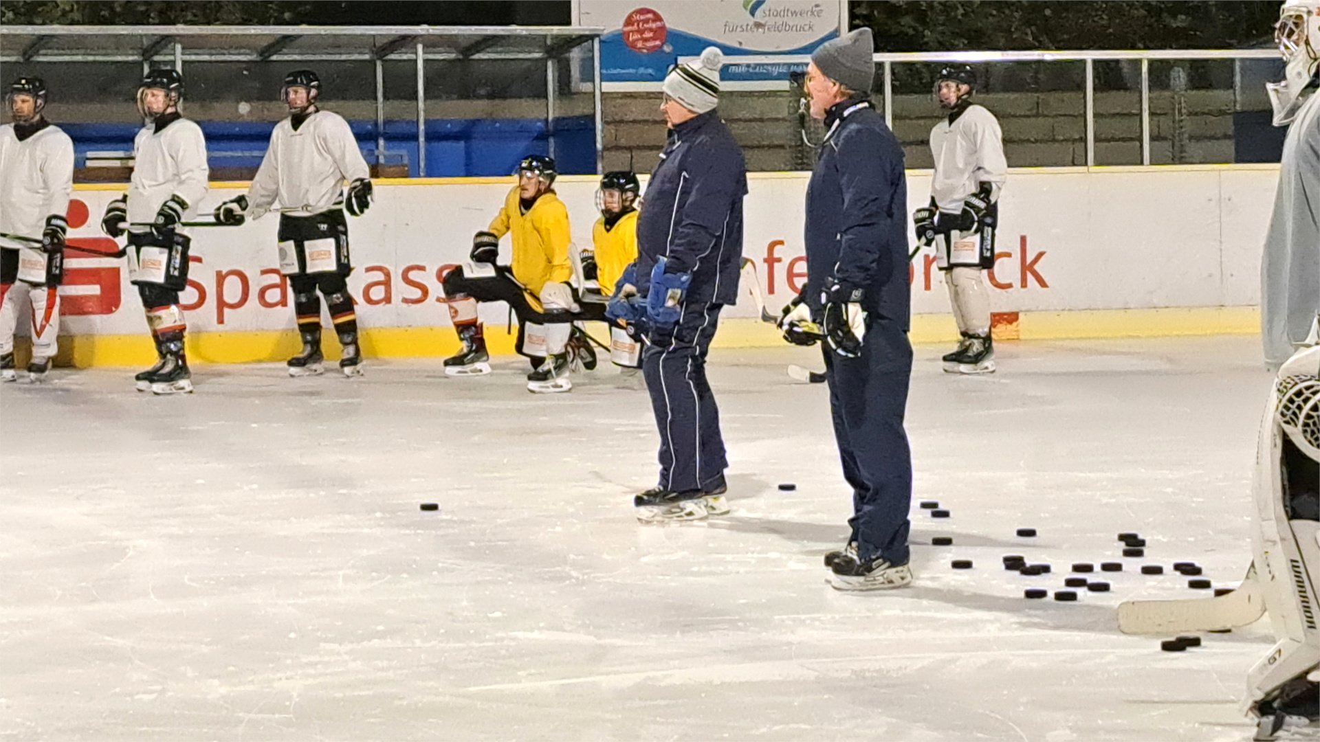 Peter Schedlbauer und Andreas Schmid mit der ersten Mannschaft des EVF im Eisstadion der Amperoase.