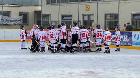 Die U13 des EVF versammelt sich vor dem Spiel gegen den MEKJ vor dem eigenen Tor.